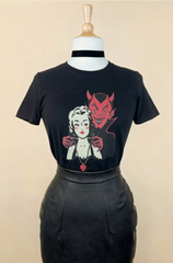 Black t-shirt with graphic design of a woman and a devil mask on a mannequin against a beige background
