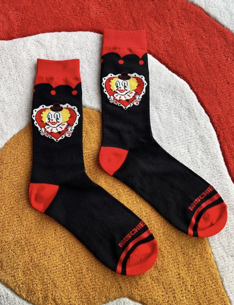 Black socks with red accents featuring cartoon character designs on a textured surface.