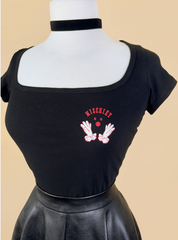 Black top with red and white graphic design on a mannequin against a beige background