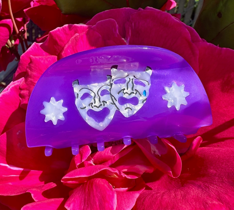 Purple hair clip with cartoon face design on pink flowers