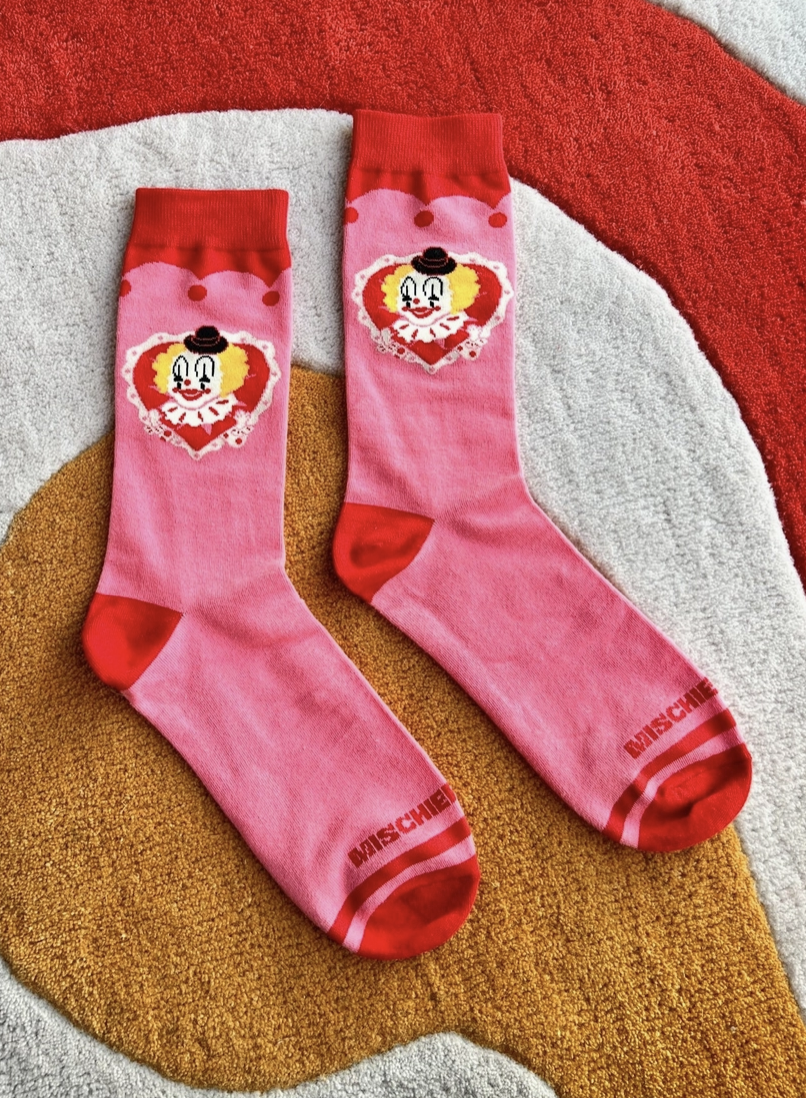 Pink socks with cartoon character design on a textured surface