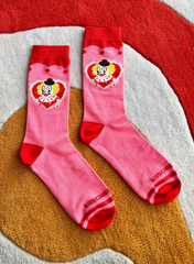 Pink socks with cartoon character design on a textured surface