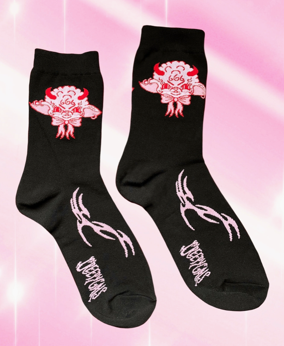 Black socks with pink and white designs on a pink background