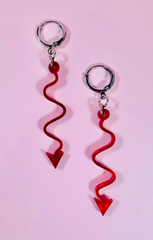 Red arrow-shaped keychains on a pink background